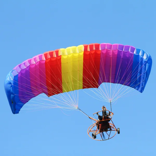 Colorful paraglider on blue bright sky — Stock Photo, Image