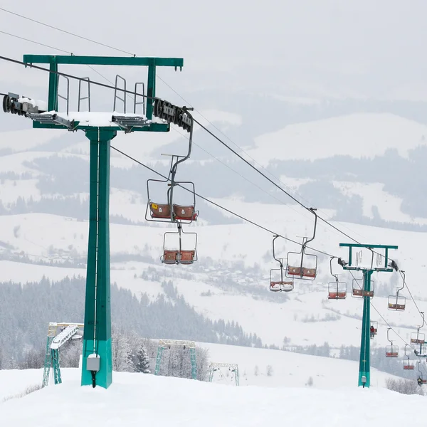 Inverno manhã paisagem de montanha com elevador de esqui e pista de esqui — Fotografia de Stock