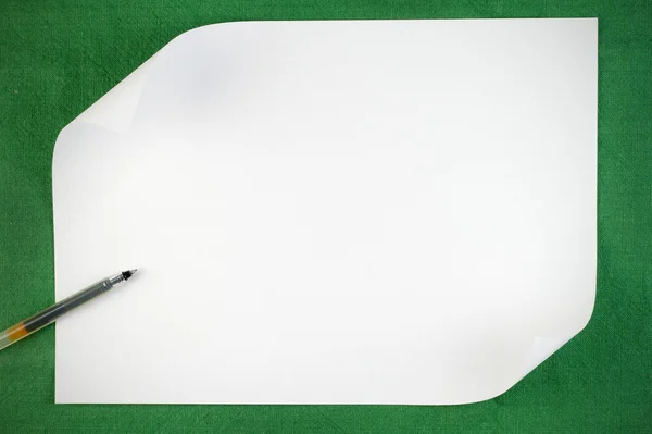 緑色の背景でカールのエッジを持つ紙の白いシート — ストック写真