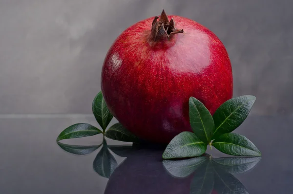 Pomegranate With Green Leaves On A Dark Background — Stock Photo, Image