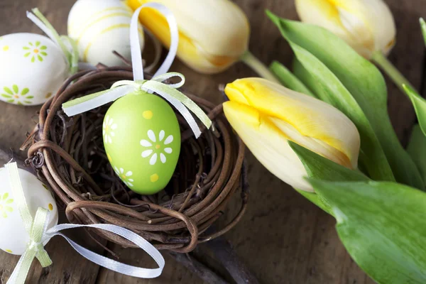 Easter eggs with yellow tulip flowers — Stock Photo, Image
