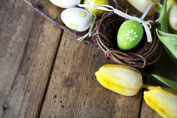 Uova di Pasqua con fiori di tulipano giallo — Foto Stock
