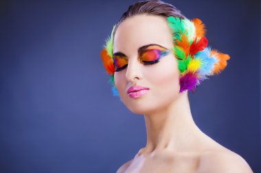 Beautiful young female face with bright fashion multicolored make-up &