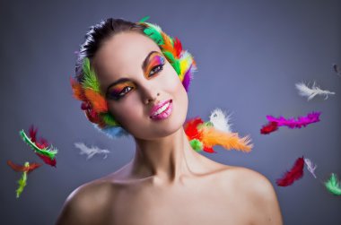 Beautiful young female face with bright fashion multicolored make-up &