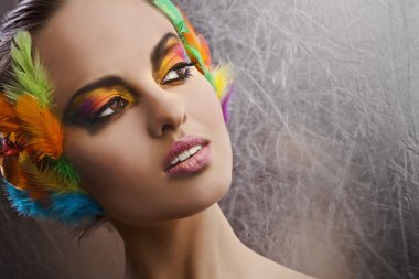 Beautiful young female face with bright fashion multicolored make-up &