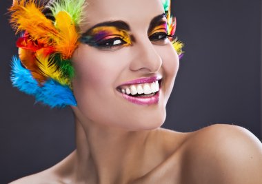 Beautiful young female face with bright fashion multicolored make-up &