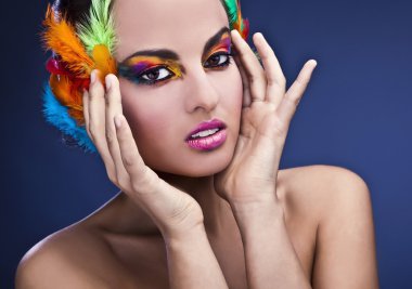 Beautiful young female face with bright fashion multicolored make-up &