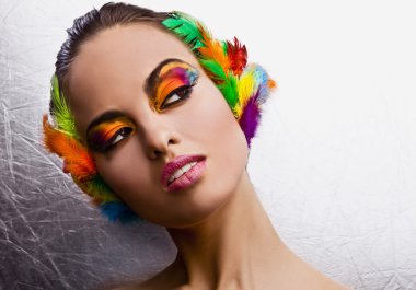 Beautiful young female face with bright fashion multicolored make-up &