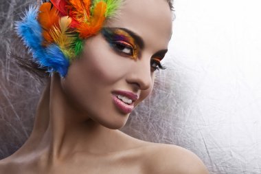 Beautiful young female face with bright fashion multicolored make-up &