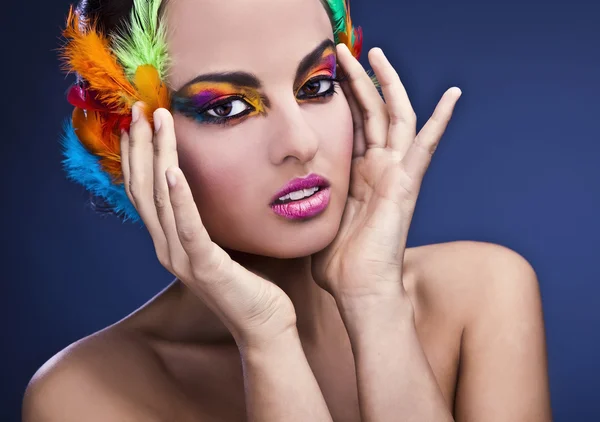 Beautiful young female face with bright fashion multicolored make-up & — Stockfoto