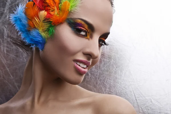 Beautiful young female face with bright fashion multicolored make-up & — 图库照片