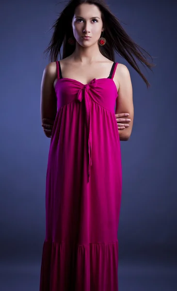 Jonge mooie brunette pose in een modieuze jurk. Studio foto. — Stockfoto