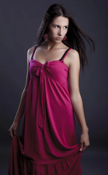 Young beautiful brunette pose in a fashionable dress. Studio photo. — Stock Photo, Image