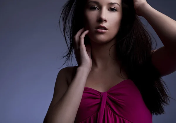 Jonge mooie brunette pose in een modieuze jurk. Studio foto. — Stockfoto
