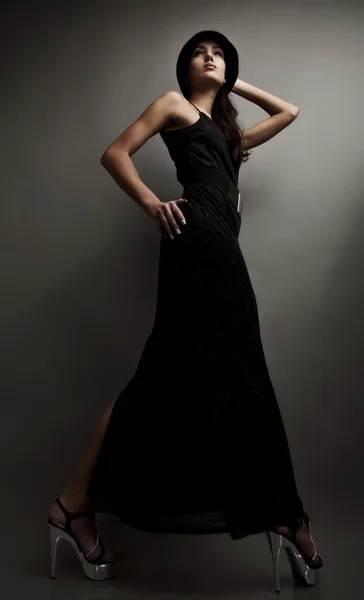 Hermosa mujer en negro vestido clásico pose en el estudio. — Foto de Stock
