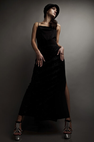 Beautiful woman on black classical dress pose in studio. Vogue style photo.