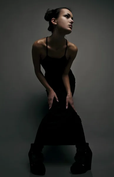Mooie vrouw op zwart klassiek jurk pose in studio. — Stockfoto