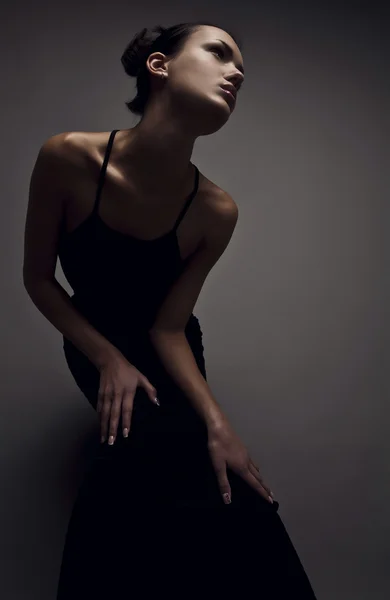 Schöne Frau im schwarzen klassischen Kleid posiert im Studio. — Stockfoto