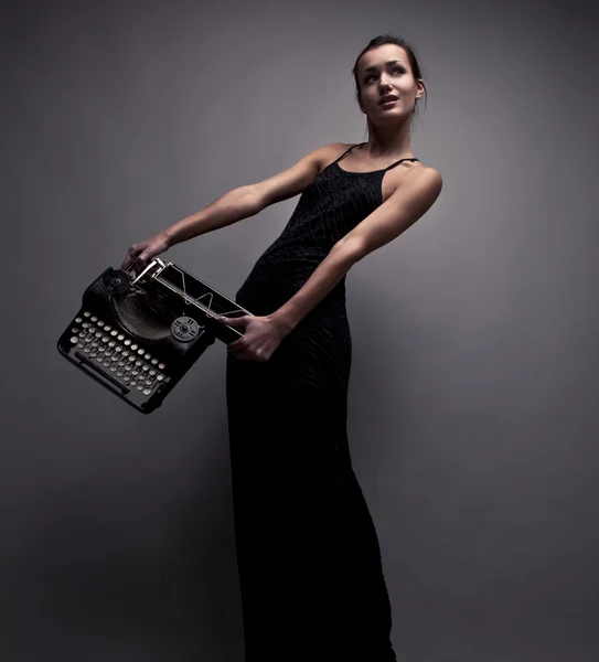 Elegante Frau posiert mit uralter Schreibmaschine. — Stockfoto