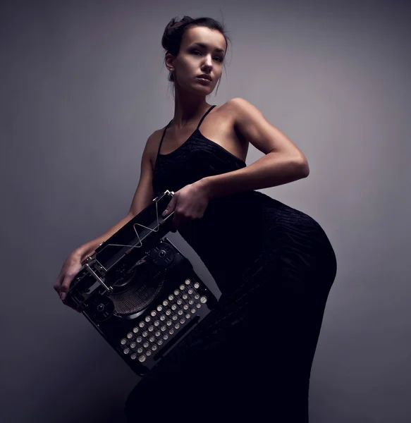 Mujer elegante pose con máquina de escribir antigua . — Foto de Stock