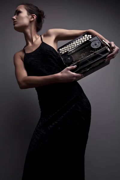 Mujer elegante pose con máquina de escribir antigua . — Foto de Stock