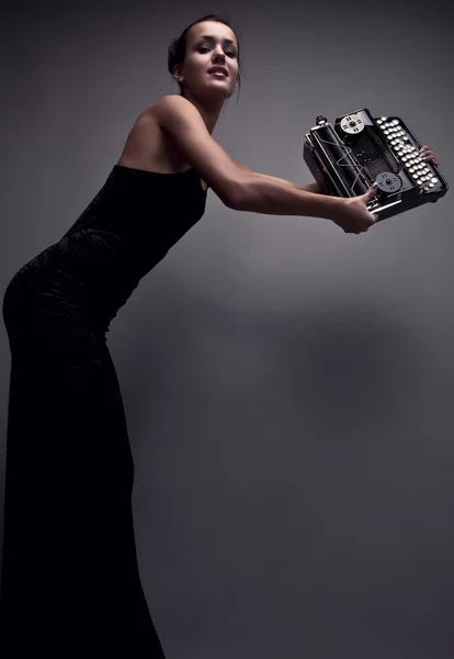 Femme élégante pose avec une ancienne machine à écrire . — Photo
