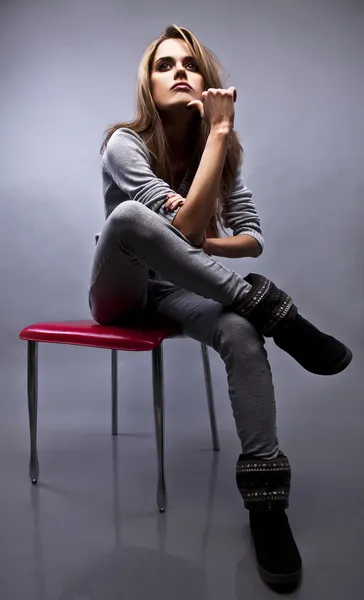 Красивая молодая женщина сидит на стуле — стоковое фото