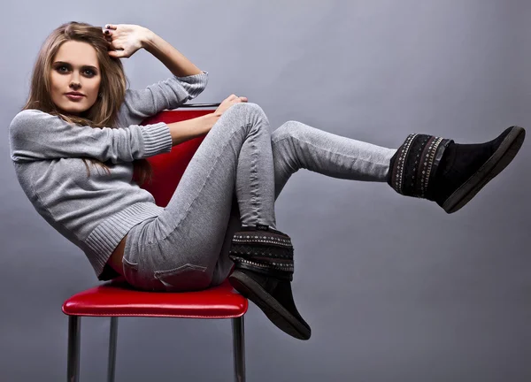 Hinreißende junge Frau sitzt auf einem Stuhl — Stockfoto
