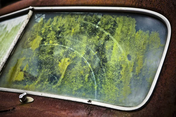 Het oude auto-venster met weerspiegeling van bomen — Stockfoto