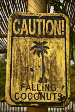 Old funny wooden caution sign on the beach. clipart