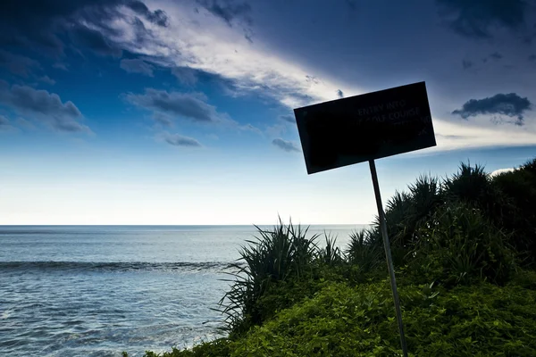 Gamla roliga trä Varning tecken på stranden. — Stockfoto