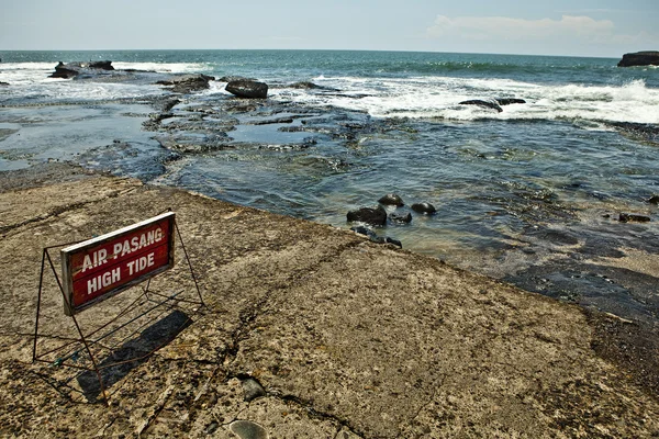 Old Sign warning tourists near ocean. — Stock Photo, Image