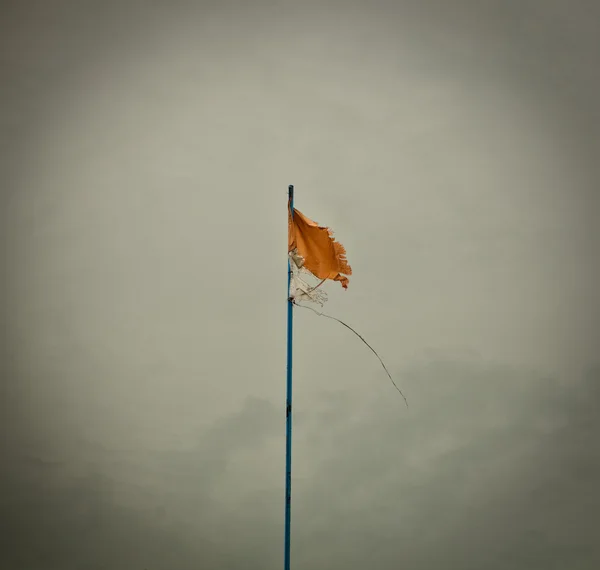 Sarı bayrak sallayarak esinti gökyüzü karşı. — Stok fotoğraf