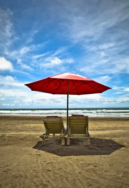 Punainen ranta sateenvarjo ja kansituolit valkoisella hiekalla. Trooppinen paratiisi — kuvapankkivalokuva