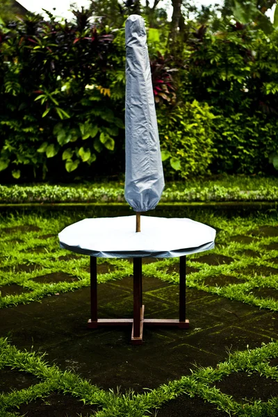 Tabela i parasolem na tarasie w ogrodzie — Zdjęcie stockowe