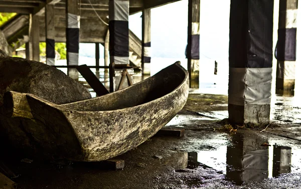 Старая деревянная лодка под мостом — стоковое фото