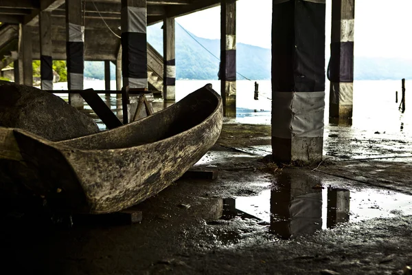 Старая деревянная лодка под мостом — стоковое фото