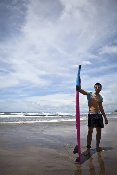 Jovem surfista atraente com uma prancha de surf — Fotografia de Stock