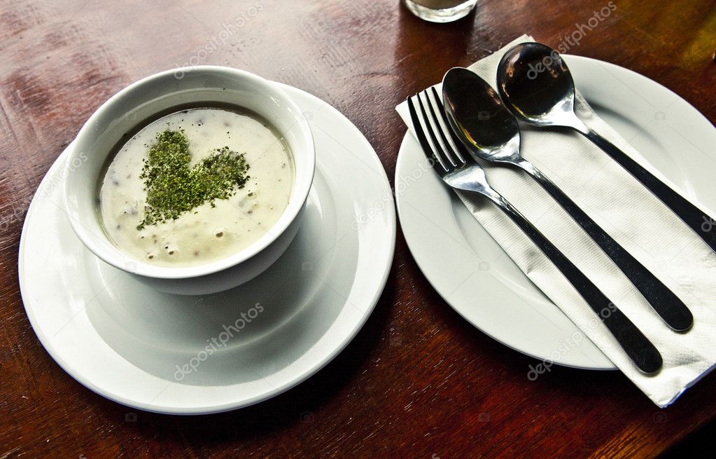 Mushroom soup with parsley in white ceramic bowl