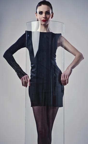Giovane bella bruna posa in un abito alla moda vicino a vetro decorativo . — Foto Stock