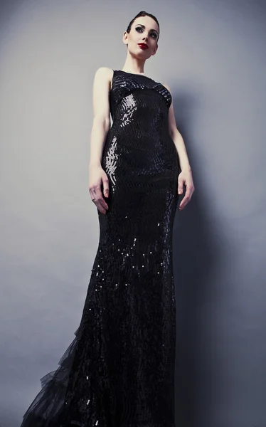 Belle femme sur robe classique noire pose en studio. — Photo