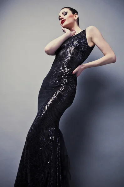 Красива жінка на чорній класичній сукні позує в студії . — стокове фото