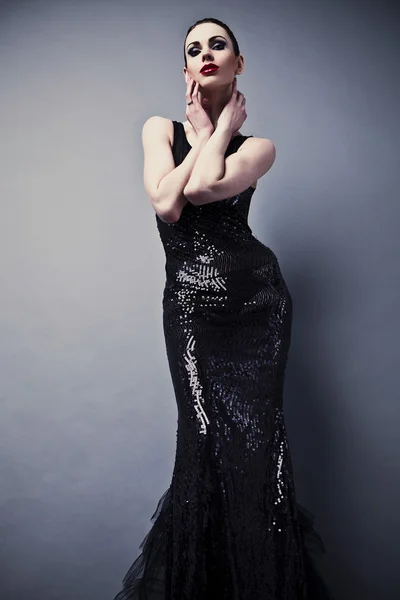 Vacker kvinna på svart klassisk klänning poserar i studio. — Stockfoto