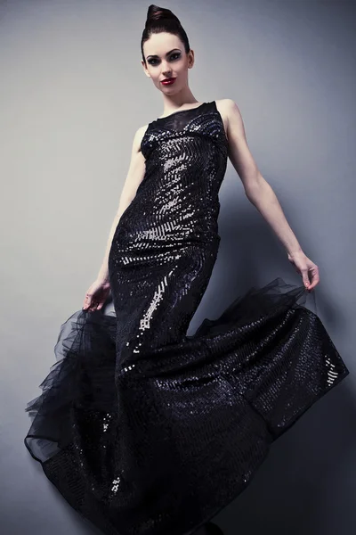 Vacker kvinna på svart klassisk klänning poserar i studio. — Stockfoto