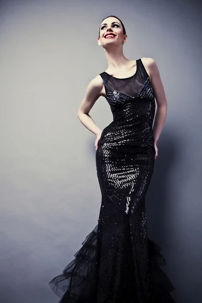 Belle femme sur robe classique noire pose en studio. — Photo