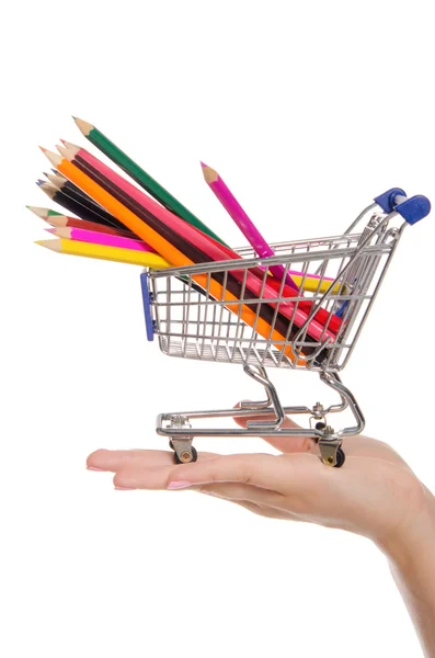 Lápis coloridos em carrinho de compras na palma da mão — Fotografia de Stock