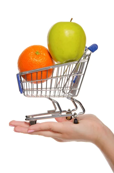 Naranja y manzana en carrito de compras en la palma — Foto de Stock