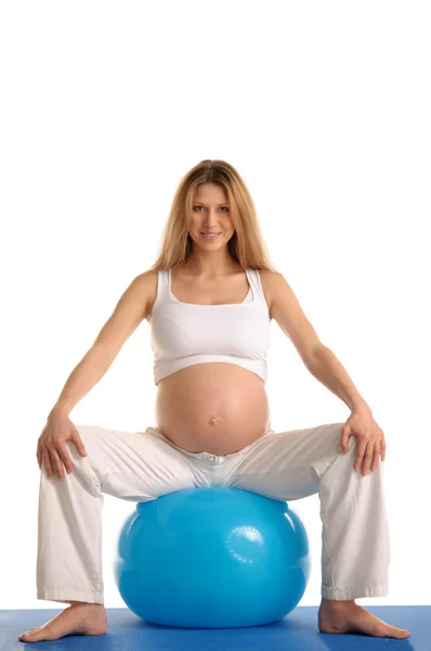 Mujer embarazada practicando yoga con bola azul — Foto de Stock