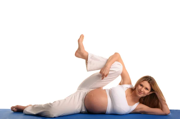 Mujer embarazada acostada y practicando yoga —  Fotos de Stock
