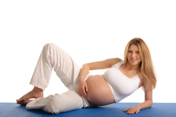 Těhotná žena vleže a cvičení jógy — Stock fotografie